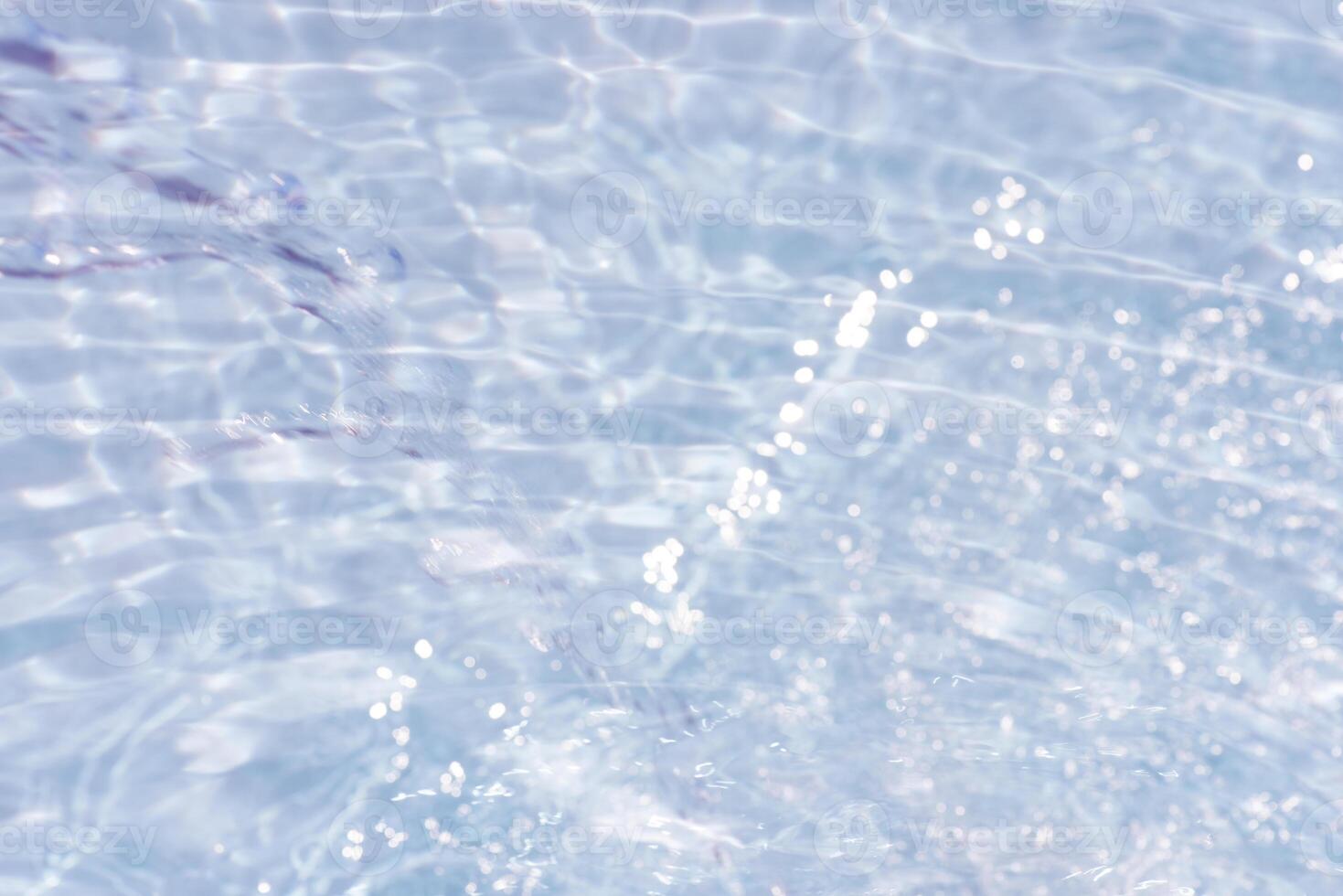 Blue water with ripples on the surface. Defocus blurred transparent blue colored clear calm water surface texture with splashes and bubbles. Water waves with shining pattern texture background. photo