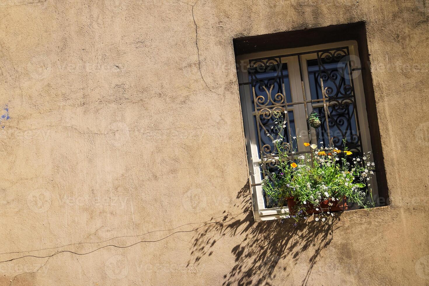 wall of a house with a window, flowers on the windowsill rustic style house facade photo