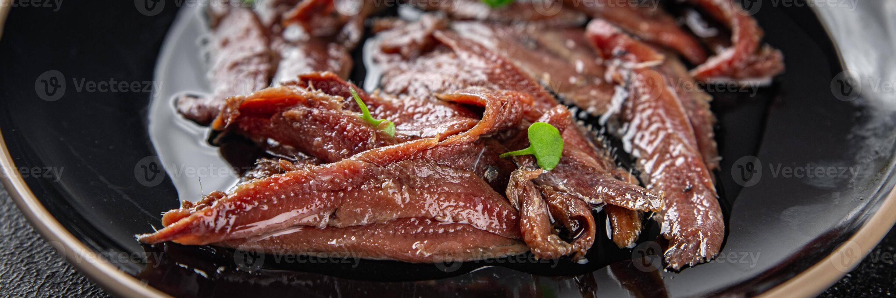anchovies in a plate on the table canned fish in oil fresh and tasty seafood meal food snack on the table copy space food background rustic photo