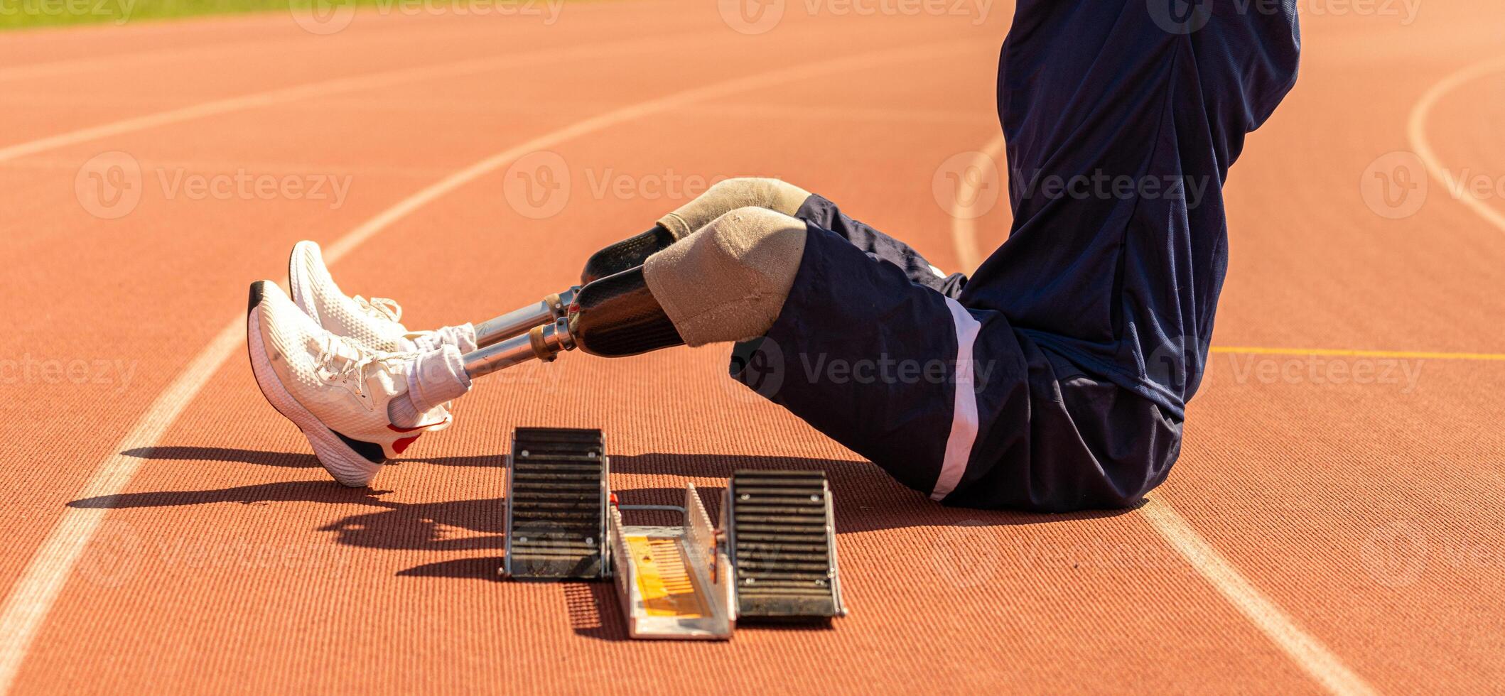 Asian para-athlete relaxes and Warm-up runner prosthetic leg on the track alone outside on a stadium track Paralympic running concept. photo