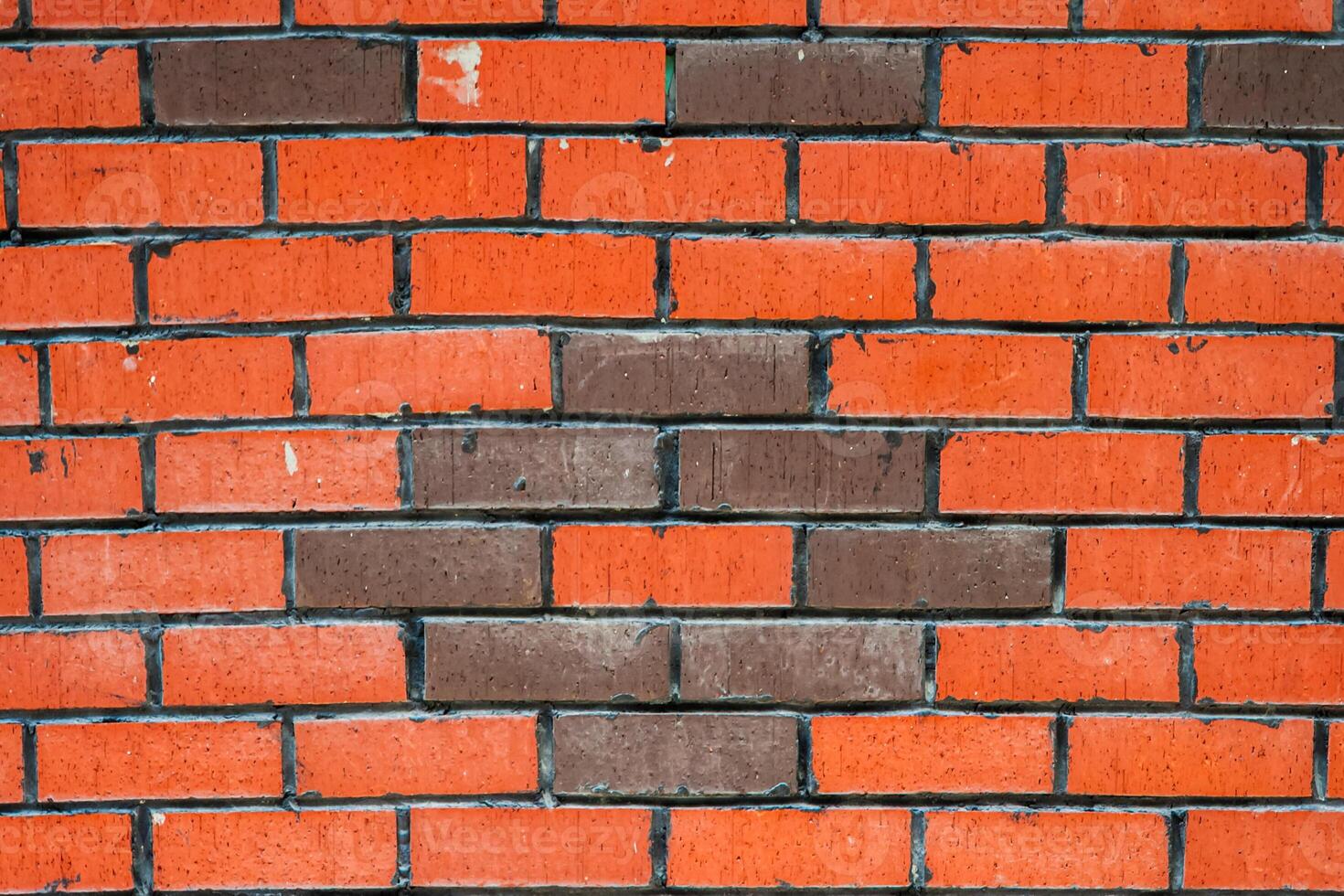 Close up of a brick wall with a unique pattern of orange and brown bricks, texture, background. photo