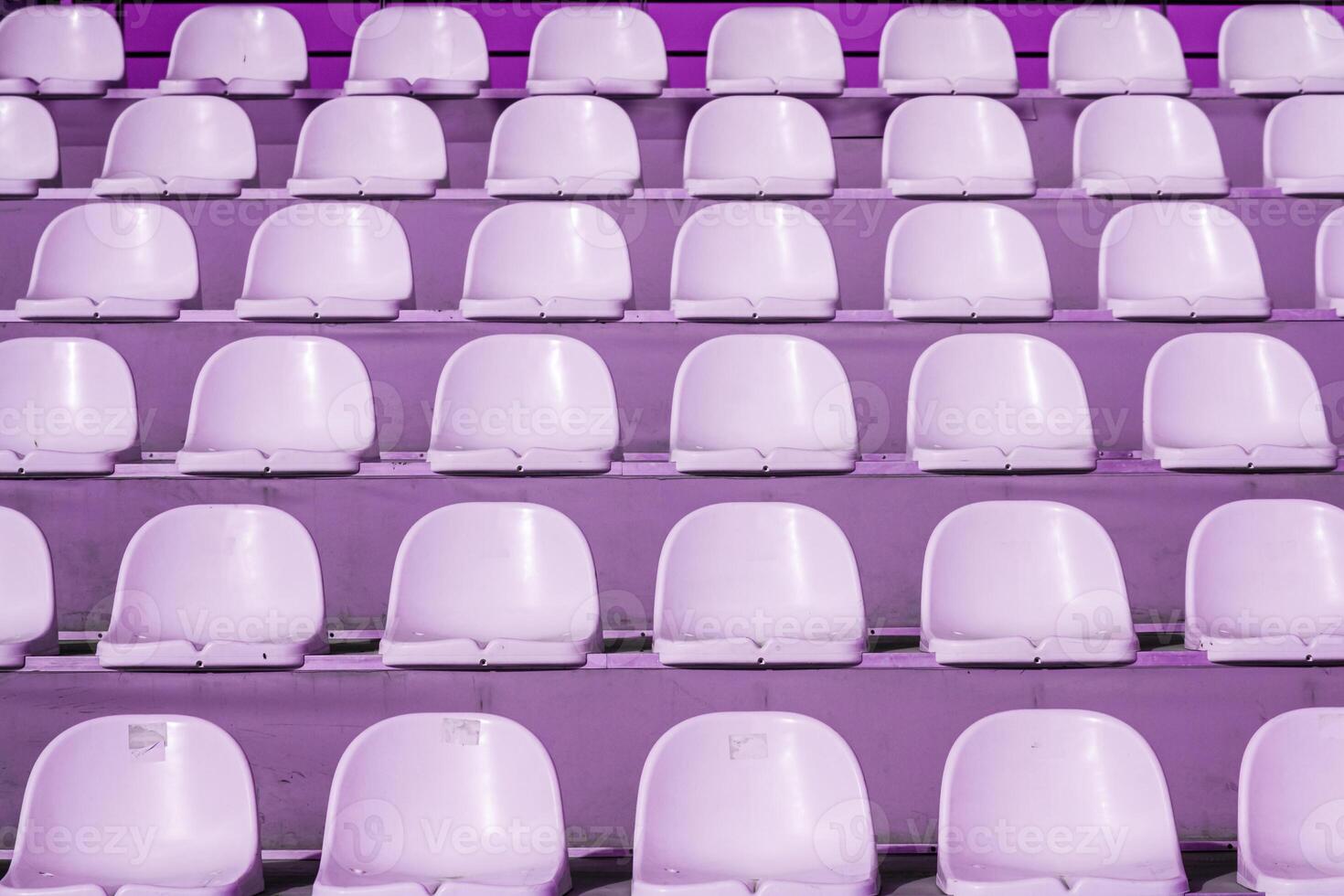 Empty rows of purple stadium seats in an outdoor setting, texture, background. photo