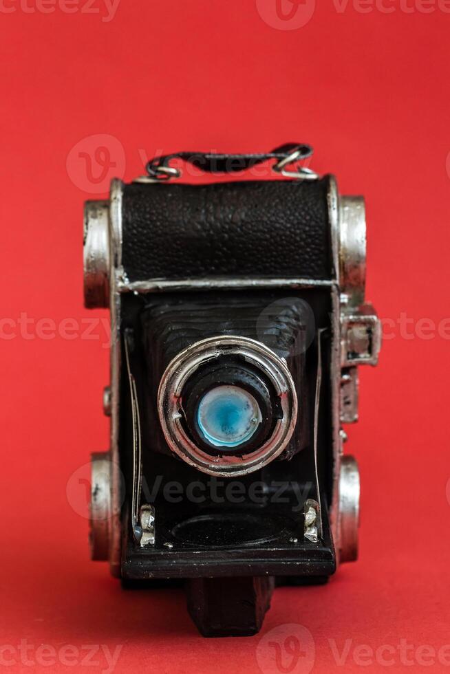 Decorative Nostalgic Camera Figurine on Red Background, Vintage Charm, Unique Perspective photo