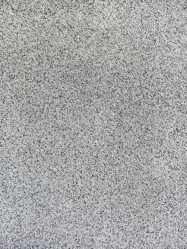 close-up texture shot of a rough, grey surface reminiscent of concrete or stucco. The granular quality and uneven shade variation make it suitable for backgrounds, graphic design photo