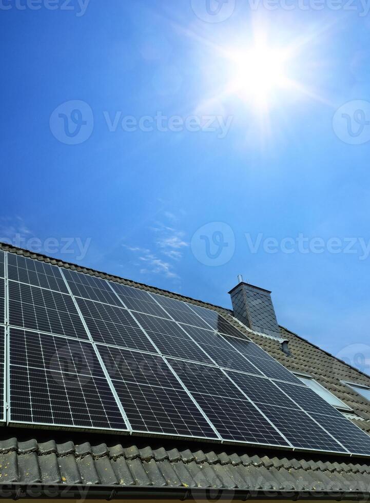 Solar panels producing clean energy on a roof of a residential house photo