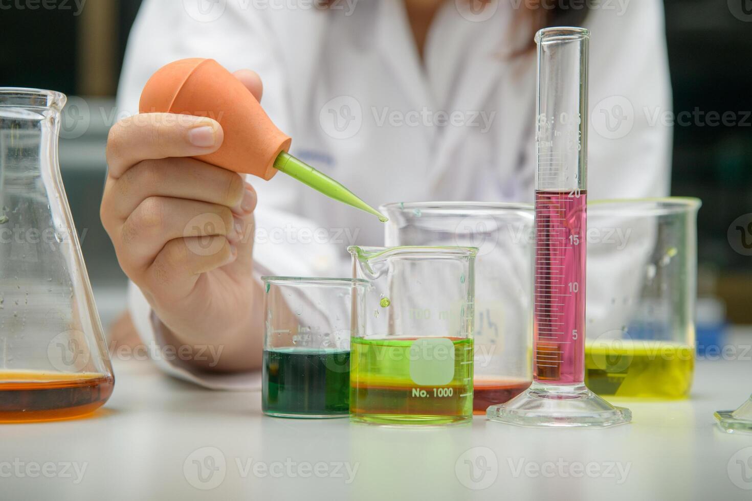 girl scientist loads liquid sample into with plastic pipette. education and science photo