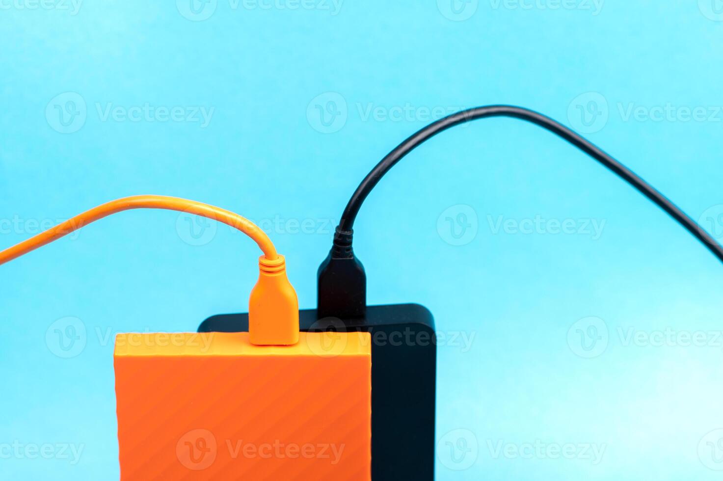 Multicolored external portable hard disk drives isolated on blue background photo