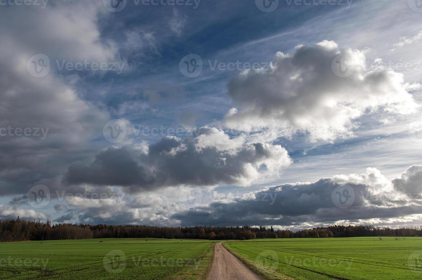 Dramatic sky with dark rain clouds over of autumnal country landscape photo