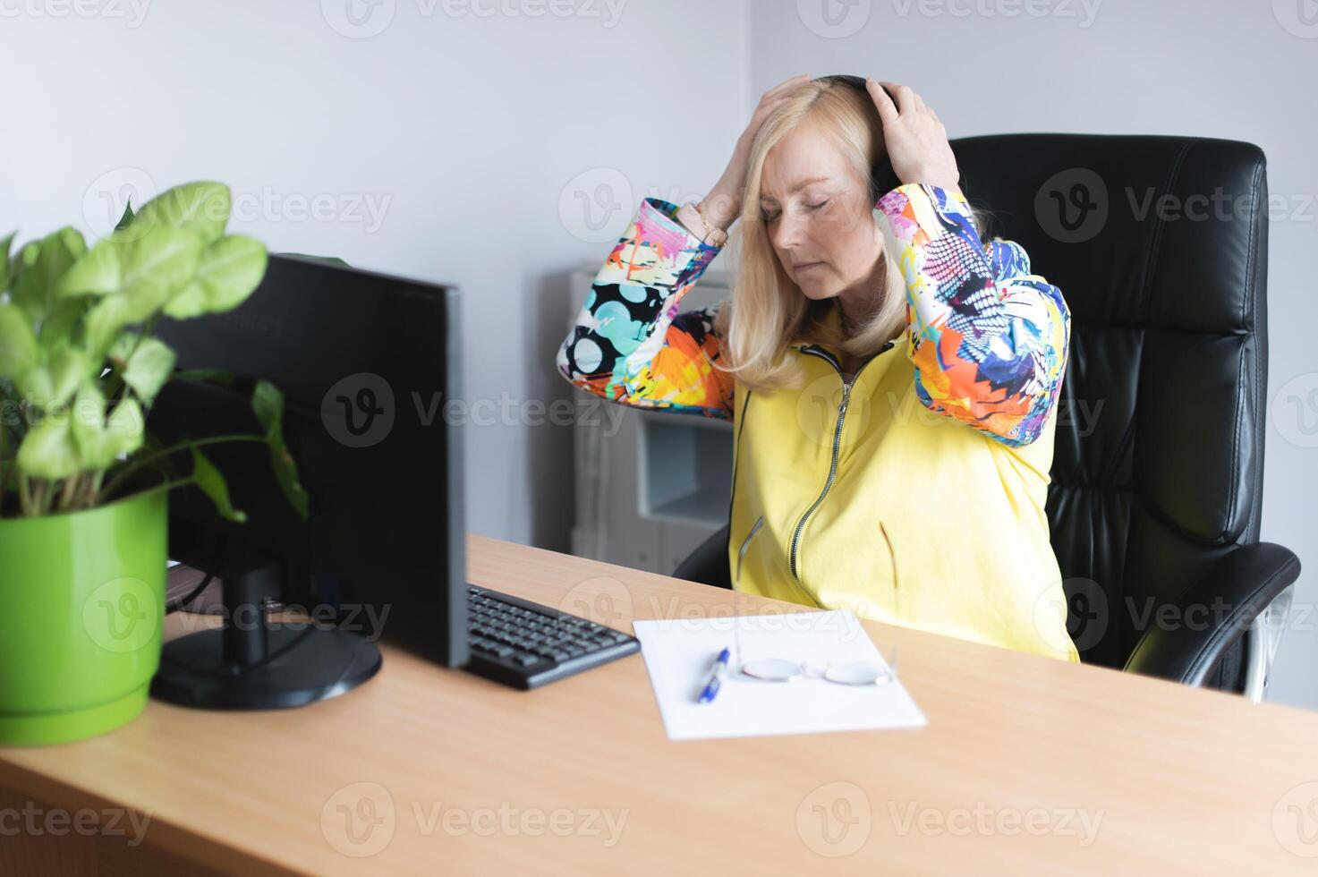 Middle aged tired, stressed and frustrated business woman desperate working at office with computer photo