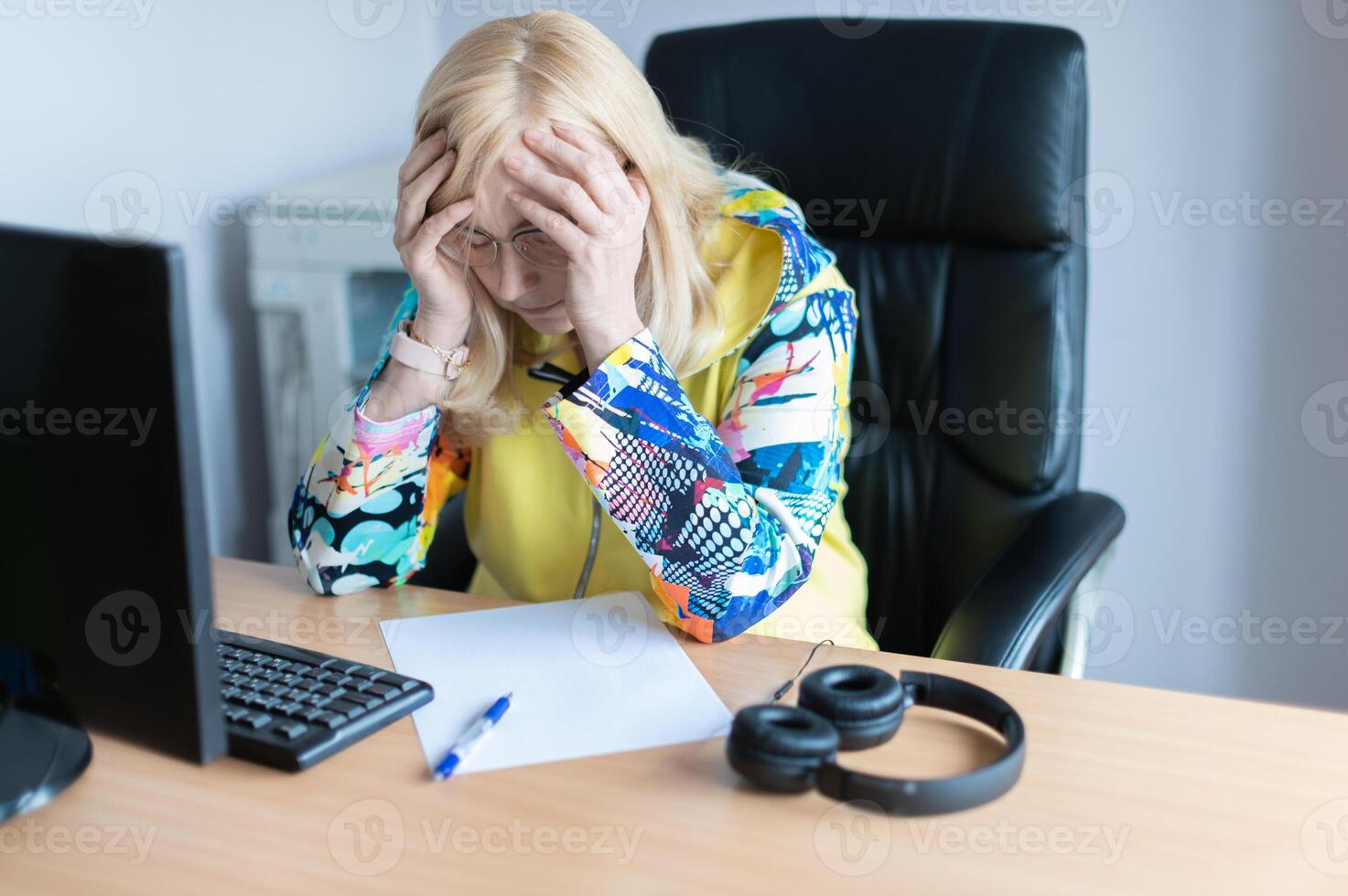 Middle aged tired, stressed and frustrated business woman desperate working at office with computer photo