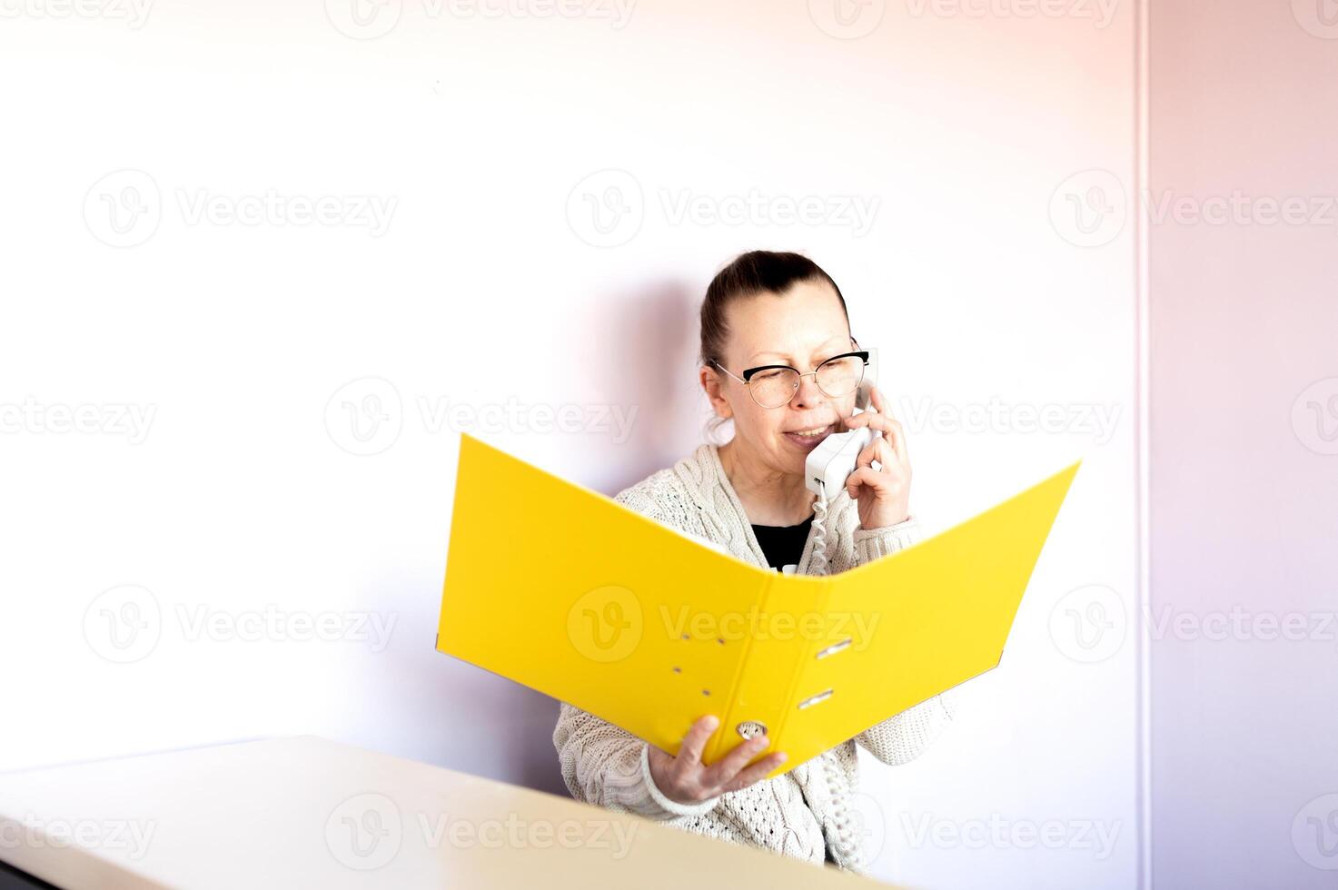 middle aged business woman talking on the phone at her office workplace photo