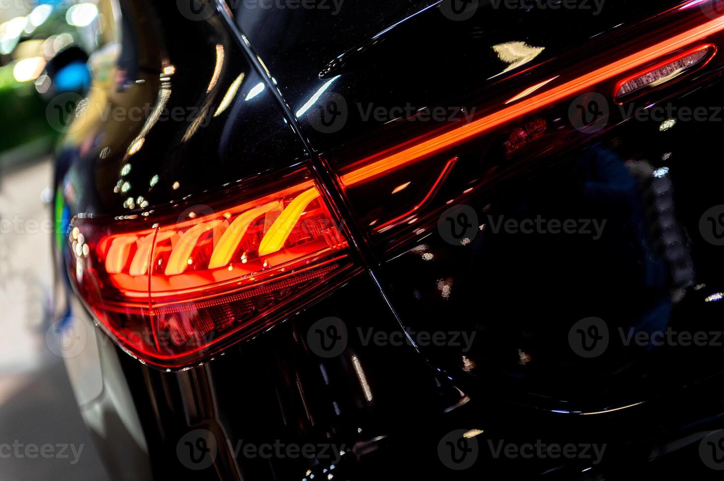 Closeup of a modern car s LED red taillight signaling turning on street to maintain distance with a closeup of the trunk photo