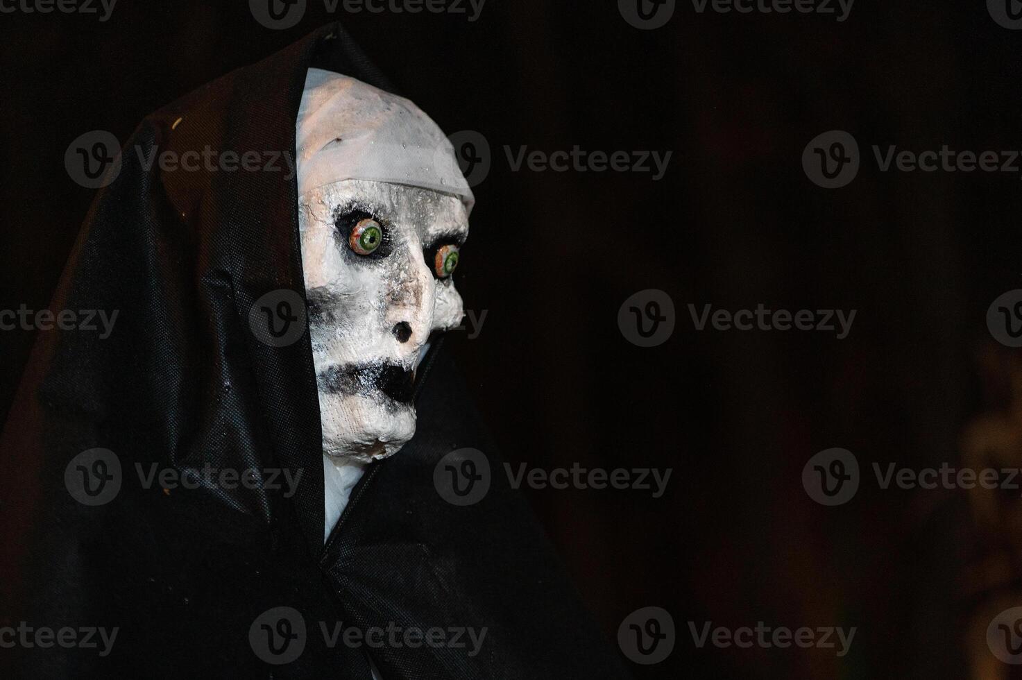 Spooky Halloween decoration stands in a wooded area creating a sinister atmosphere photo