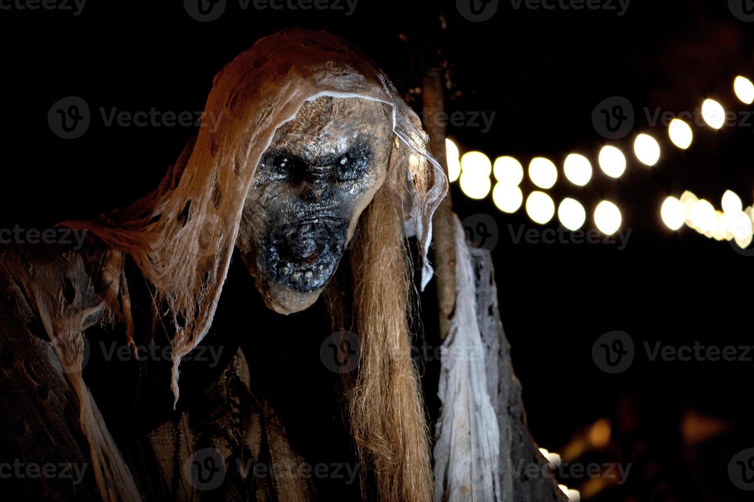Spooky Halloween decoration stands in a wooded area creating a sinister atmosphere photo