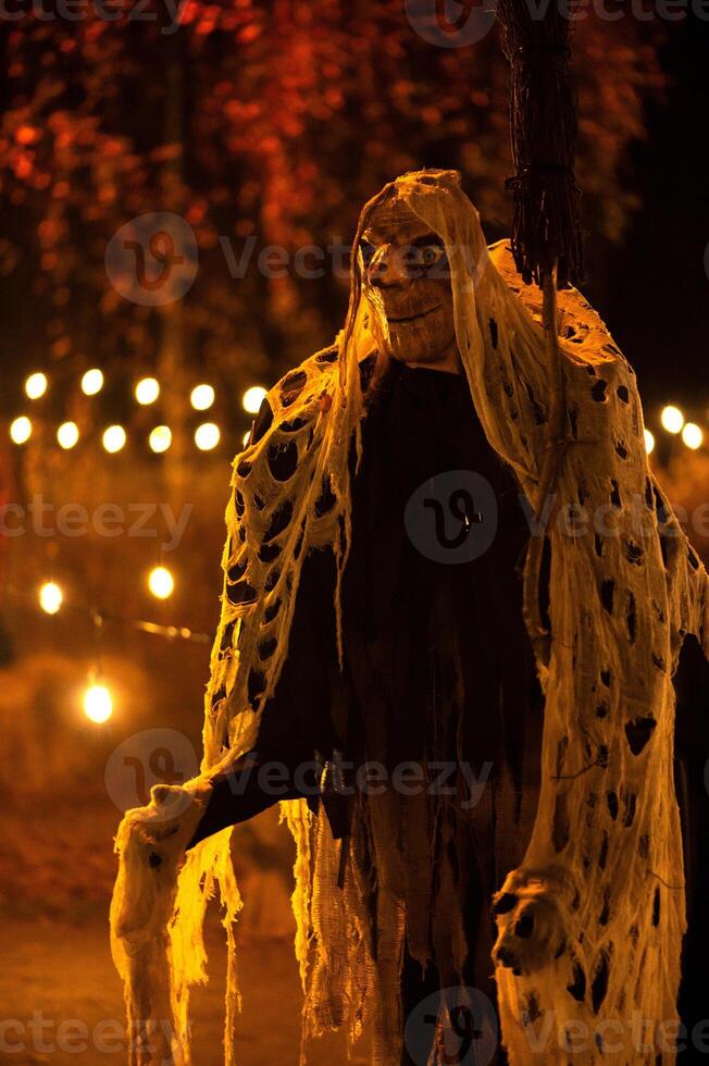 Spooky Halloween decoration stands in a wooded area creating a sinister atmosphere photo