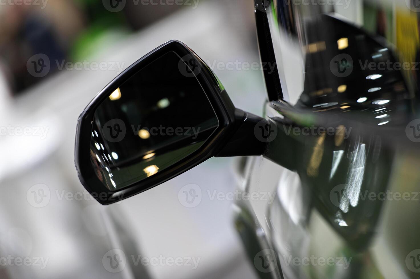 A blurred night scene viewed from a car side mirror capturing the motion of city lights and passing vehicles on a wet road photo