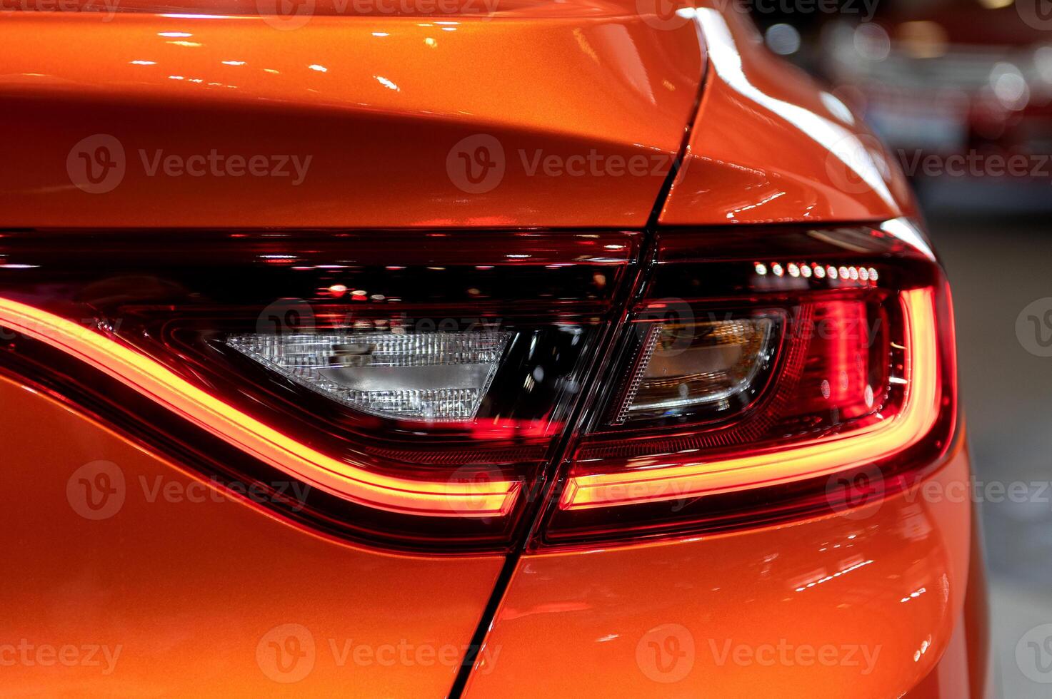 Closeup of a modern car s LED red taillight signaling turning on street to maintain distance with a closeup of the trunk photo