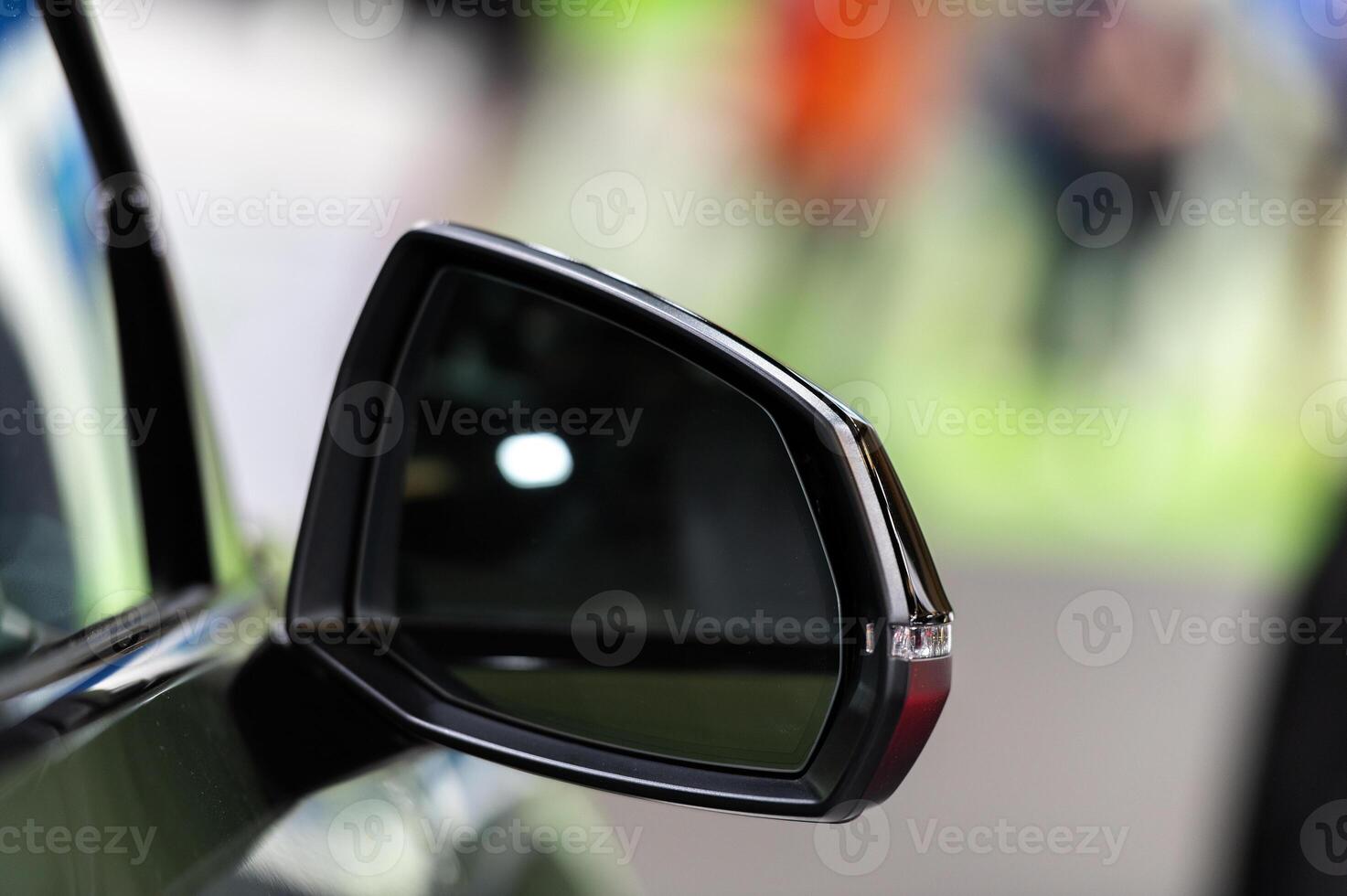 A blurred night scene viewed from a car side mirror capturing the motion of city lights and passing vehicles on a wet road photo