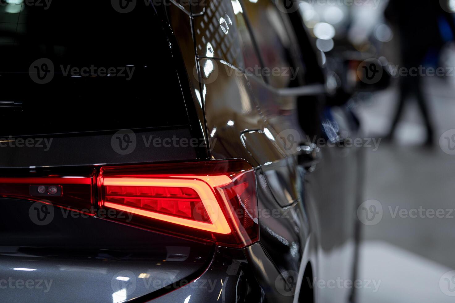Closeup of a modern car s LED red taillight signaling turning on street to maintain distance with a closeup of the trunk photo