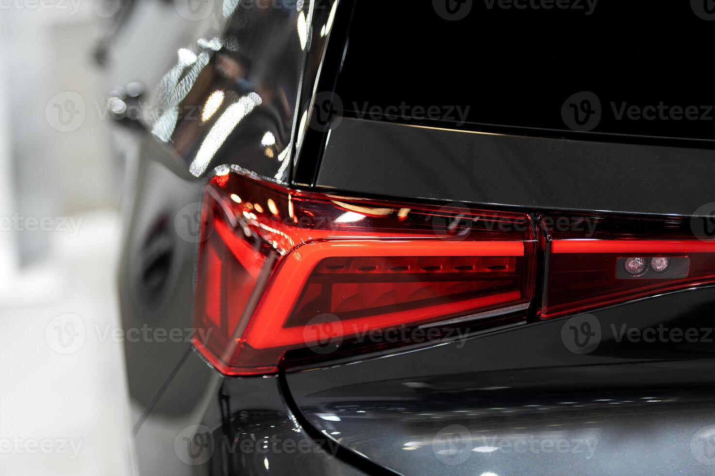 Closeup of a modern car s LED red taillight signaling turning on street to maintain distance with a closeup of the trunk photo