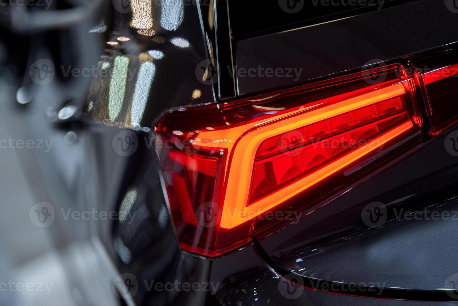 Red illuminated LED taillight on the back of a car at night photo