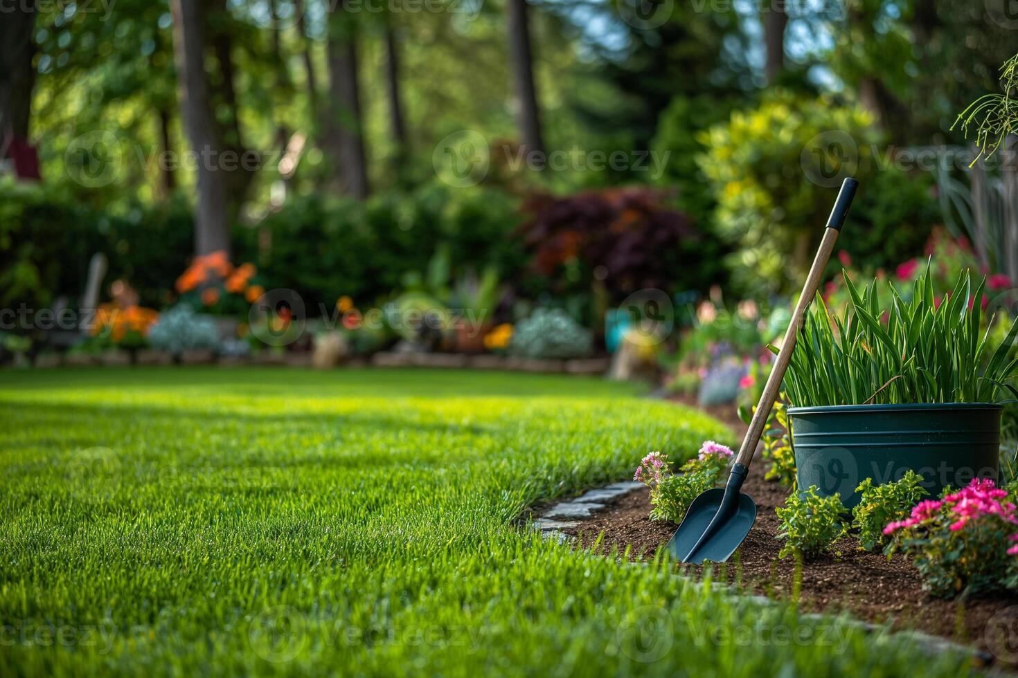 gardening tools on a green lawn with flower beds photo