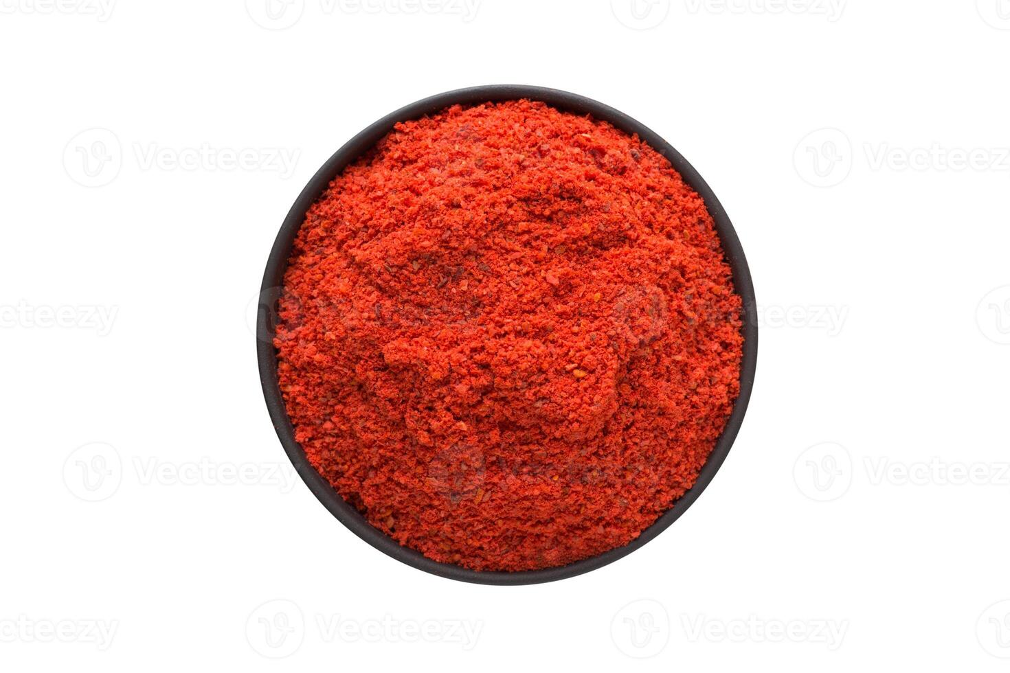 Adjika powder in clay bowl isolated on white background. Seasoning or spice top view photo