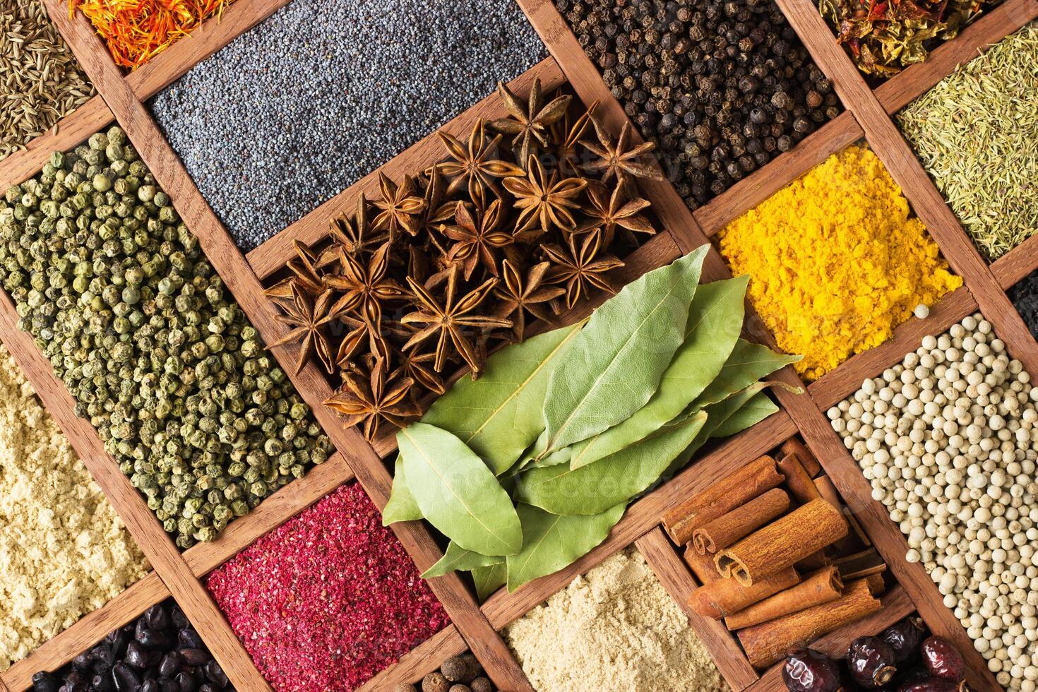 Bright herbs and spices in wooden trays on shop window. Set seasonings for cooking, in box with cells. photo
