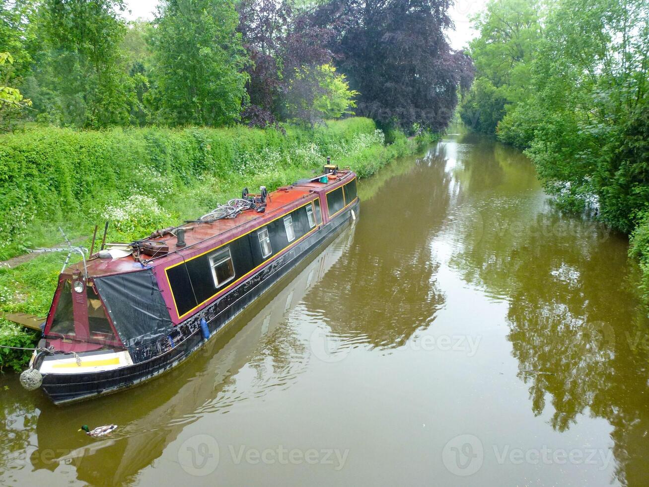 english canal with narrow old houseboats photo