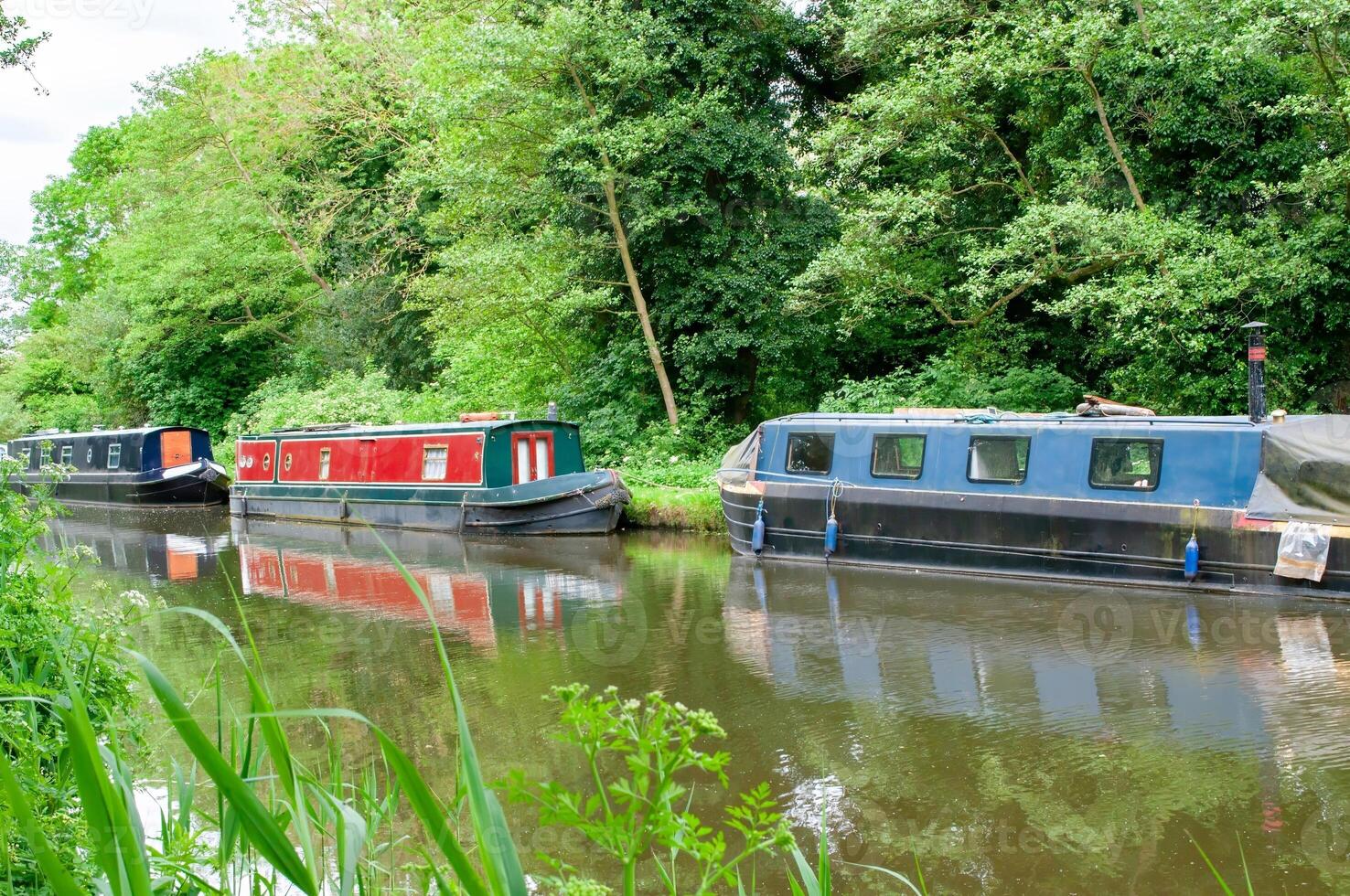 english canal with narrow old houseboats photo