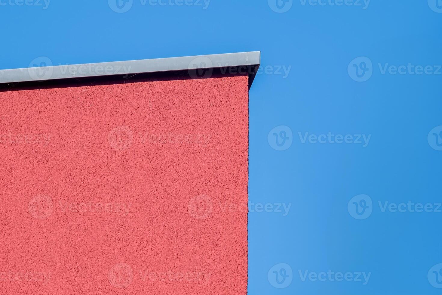 orange painted house wall in front of a blue sky photo