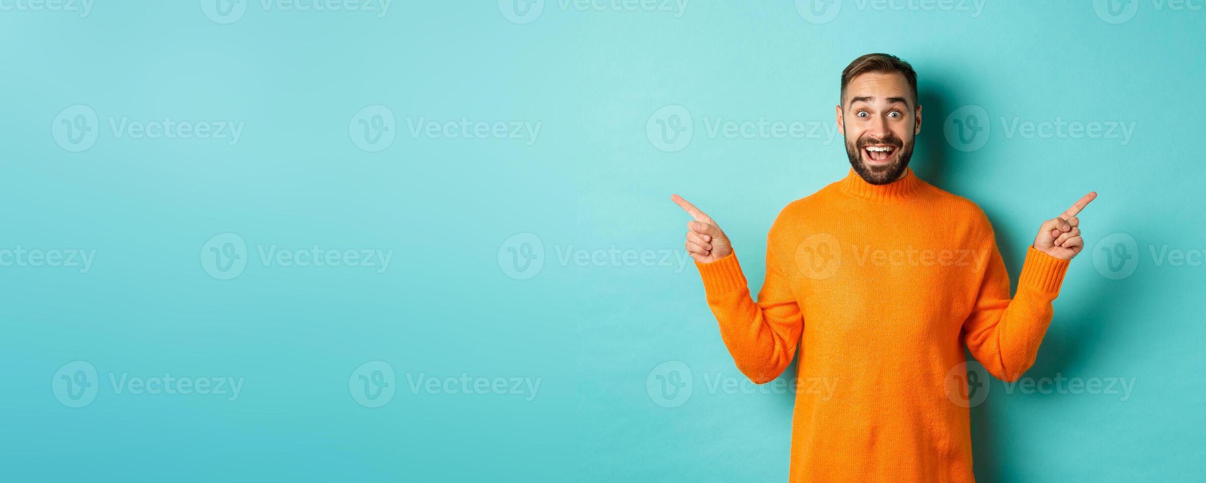 Shopping and advertisement concept. Excited man buyer pointing fingers sideways, showing two choices products, left and right banners, standing over light blue background photo