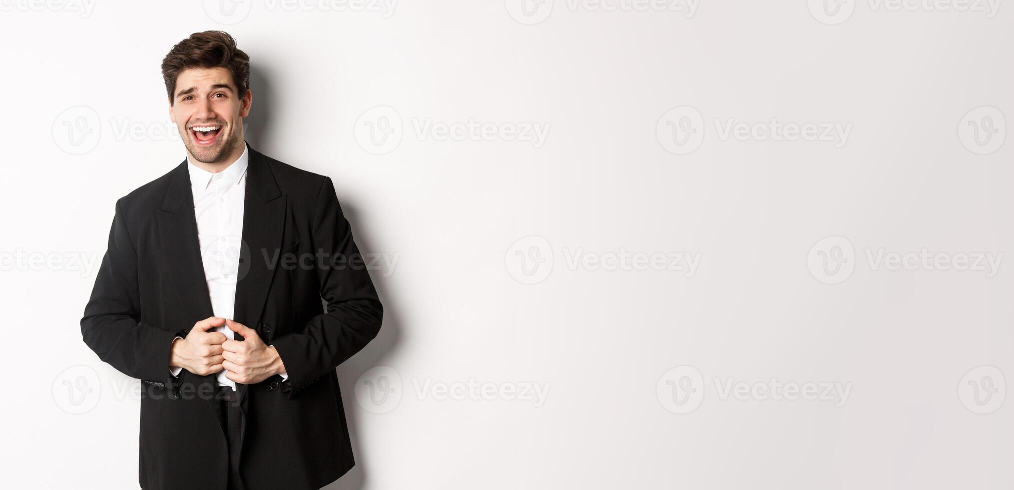 Concept of new year party, celebration and lifestyle. Portrait of handsome and confident man in suit, smiling pleased, feeling successful, standing over white background photo