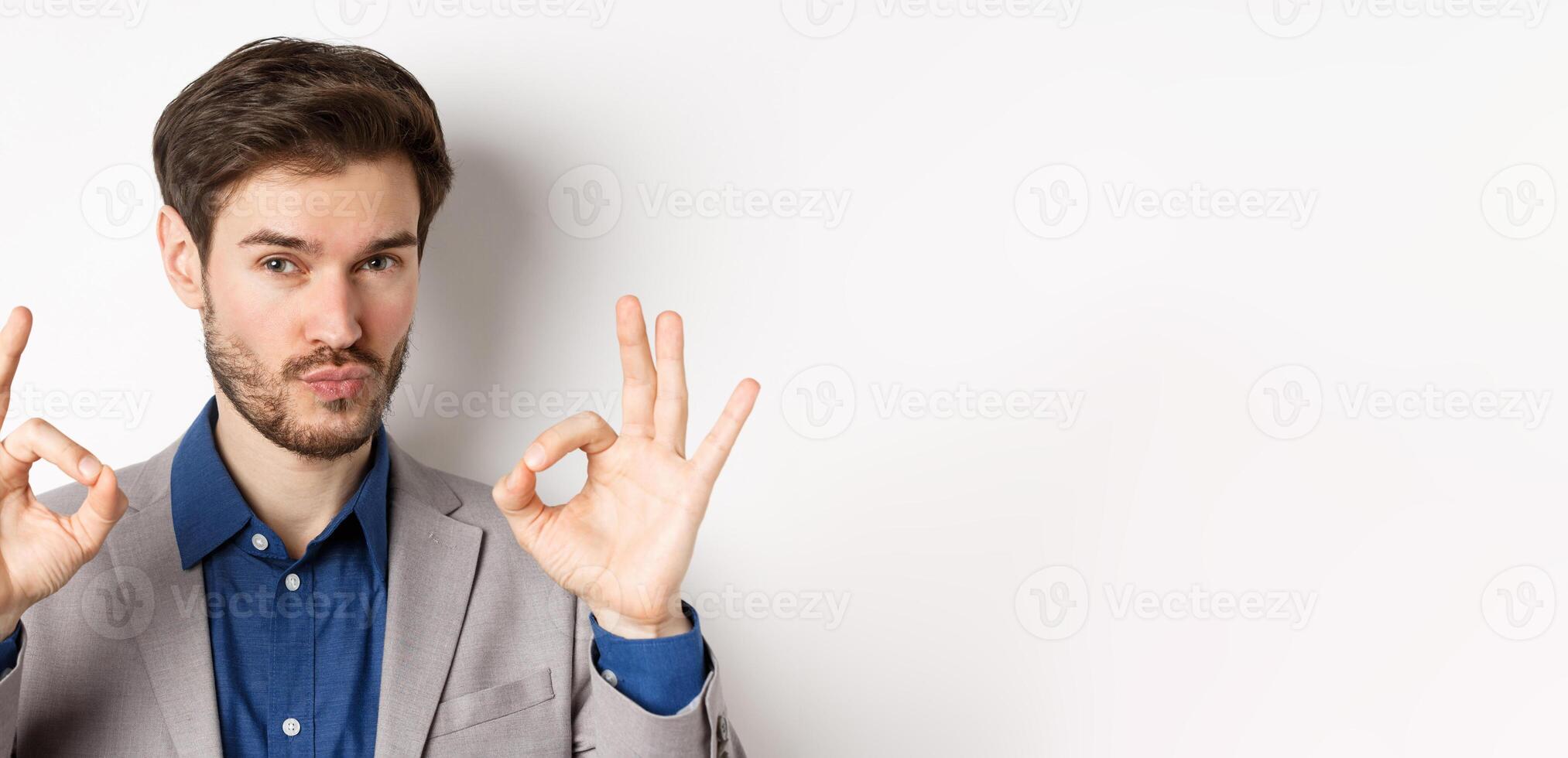Not bad. Impressed caucasian businessman nod in approval, showing okay signs to praise and make compliment, white background photo