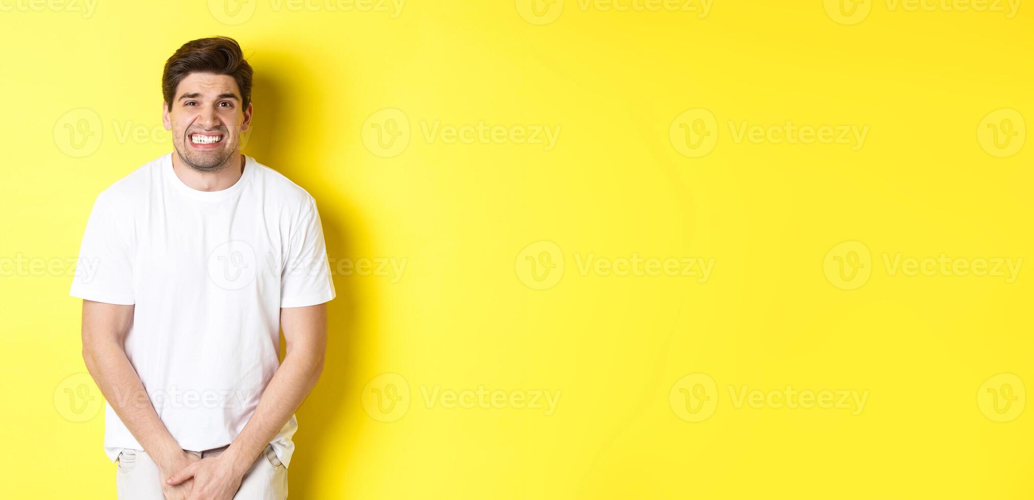 Bladder problem. Man need to toilet, holding hands on crotch and grimacing, urinal dysfunction. Copy space photo
