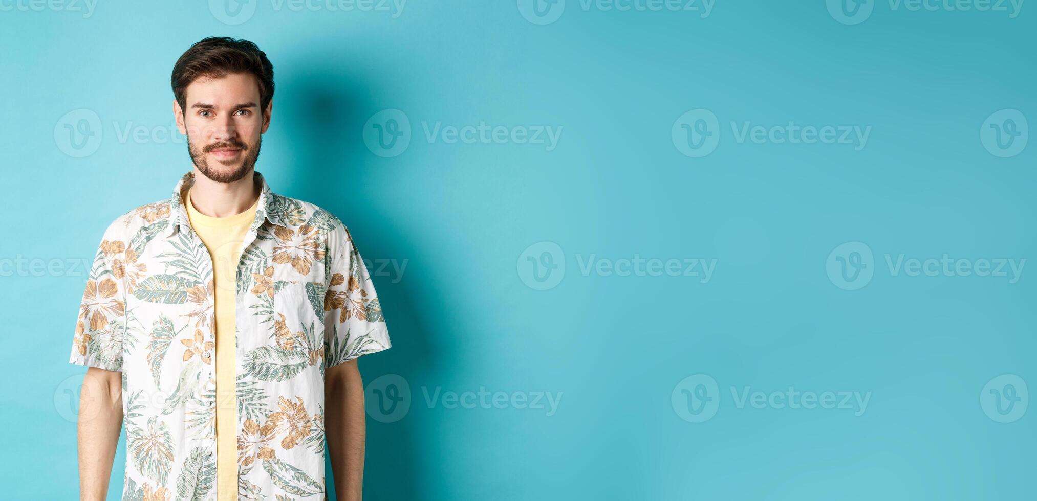 Happy handsome guy smiling, wearing hawaiian shirt on vacation. Concept of summer holiday photo