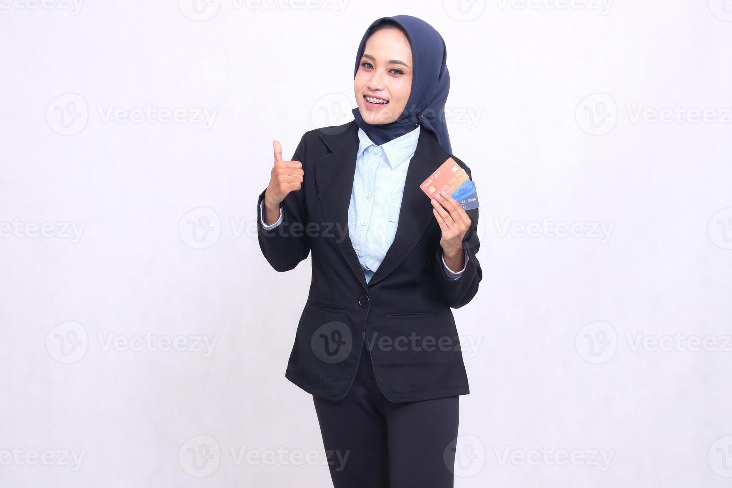 mature asian office woman in hijab standing happy gesture thumbs up like nice and carry credit debit card. adult Muslim blue shirt for finances, transactions and loans photo