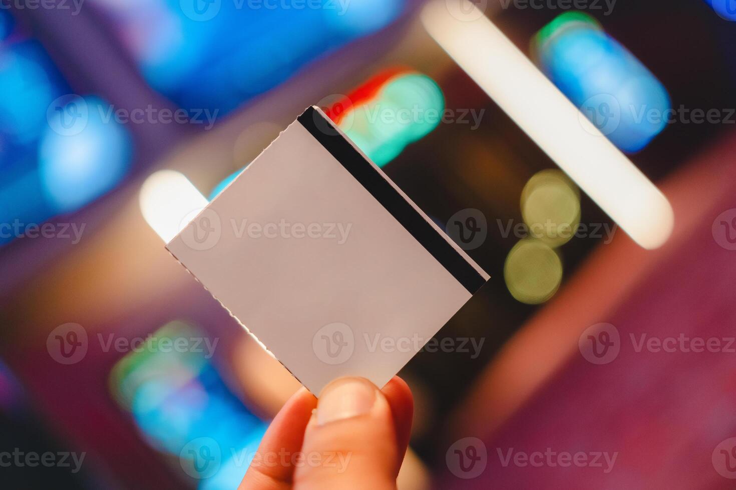 Person holding up an empty movie paper ticket. photo