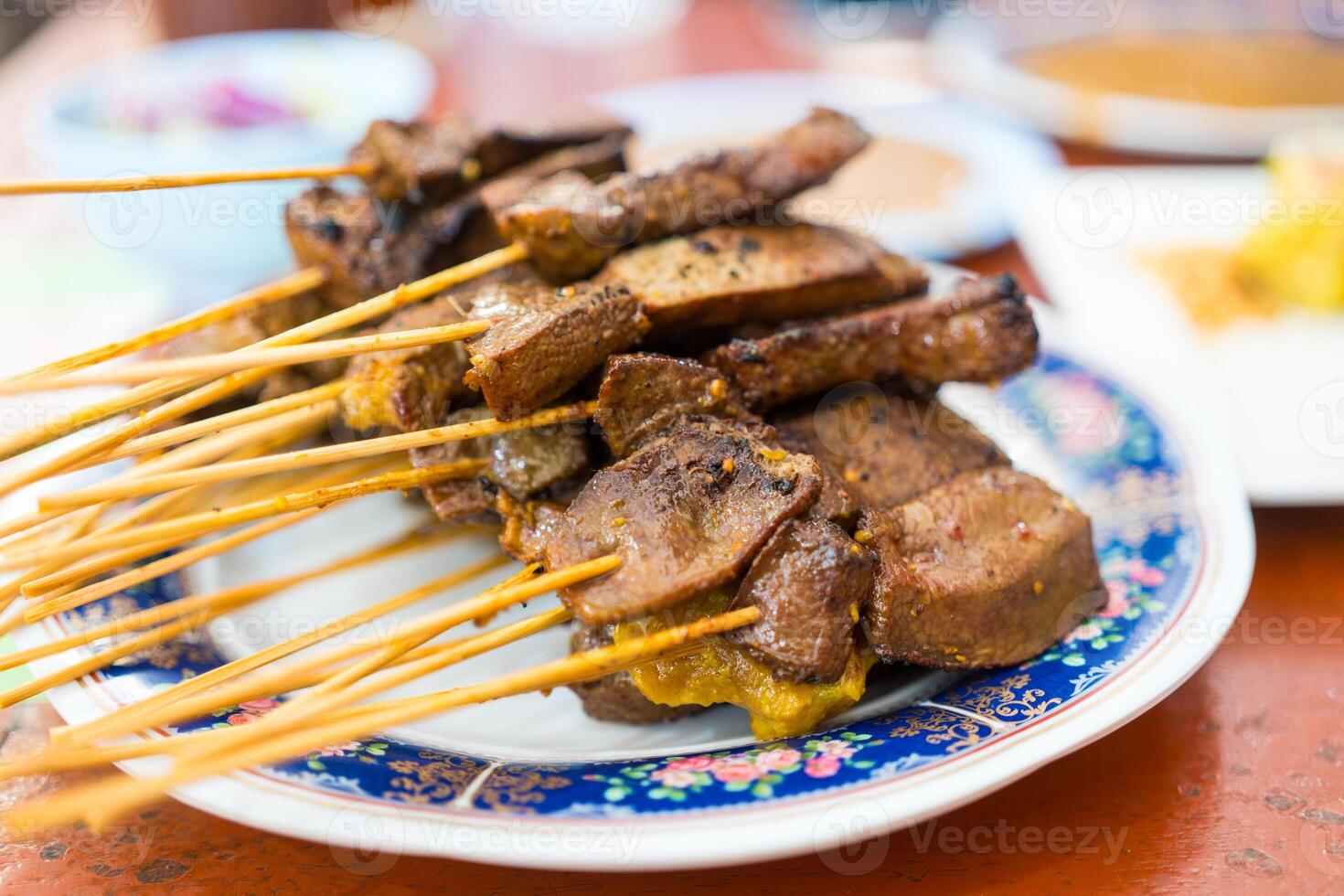 Liver satay or liver pork in bamboo skewers eaten with peanut sauce or sweet and sour sauce. photo