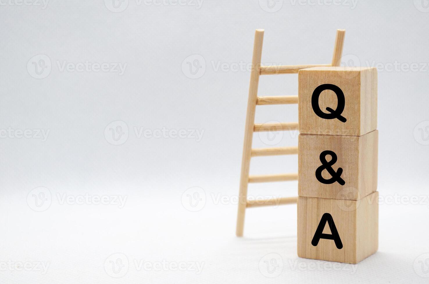 Question and Answer - Q and A text on wooden cubes with wooden ladder background photo