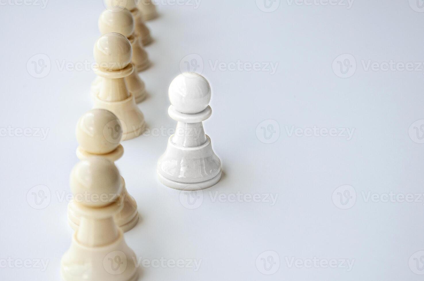 White shining pawn stepping out from the rest of the soldier pawn. Leadership concept. photo