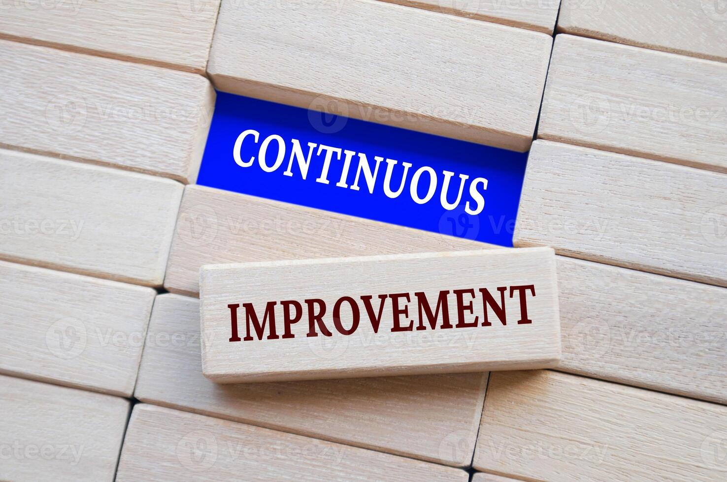 Top view of continuous improvement text on wooden blocks. Business strategy concept. photo