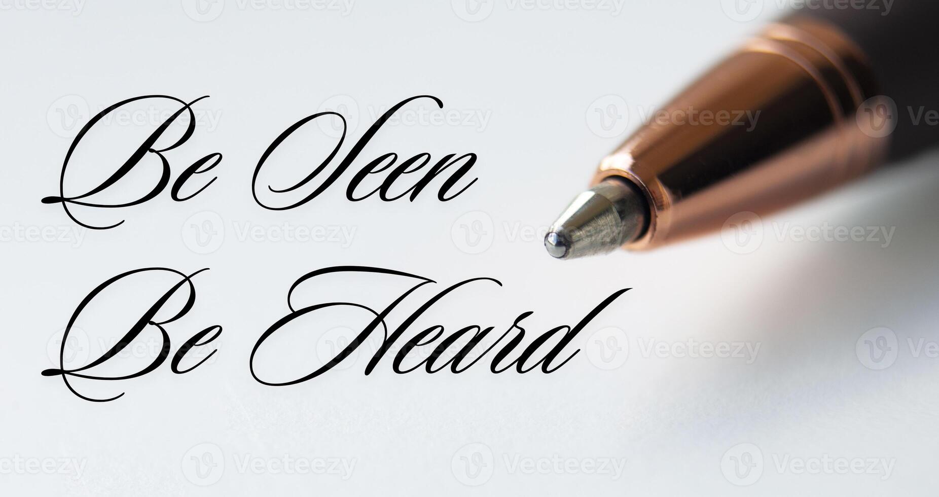 Be seen be heard text with closeup pen on white cover background photo