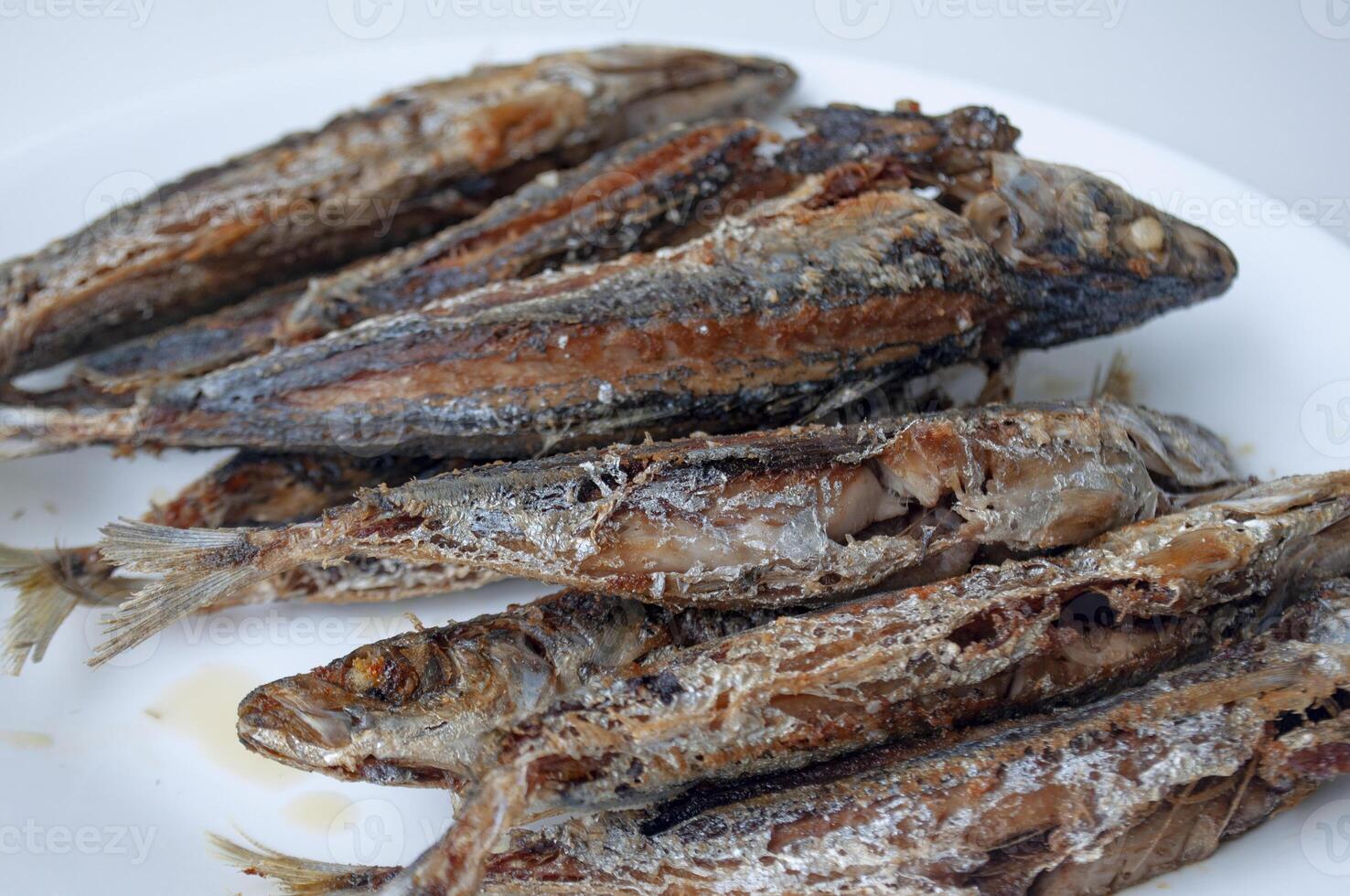 Deep fried sardines fish on white place. Asian food concept photo