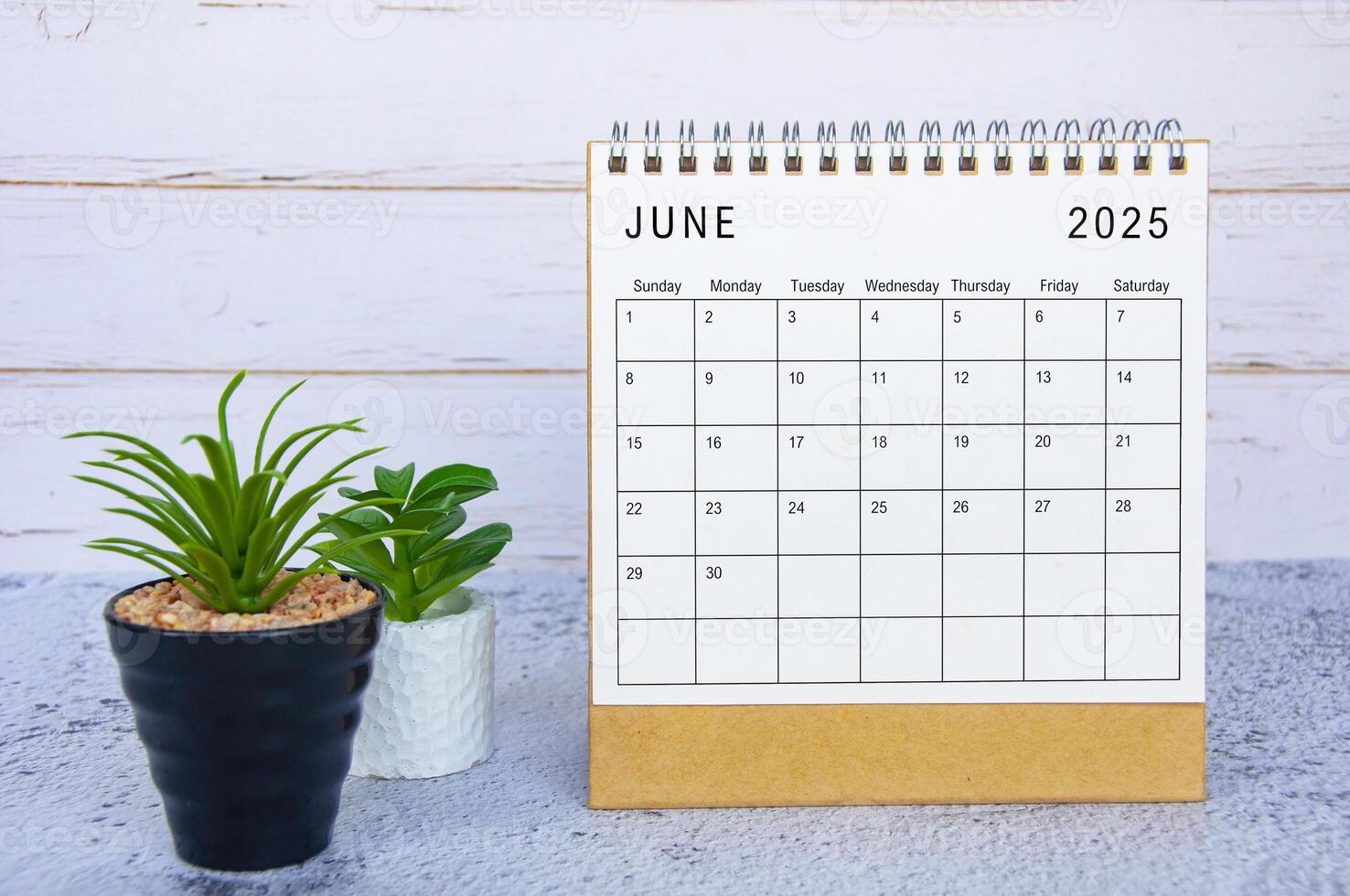 June 2025 calendar with white wooden background. New month and calendar concept photo