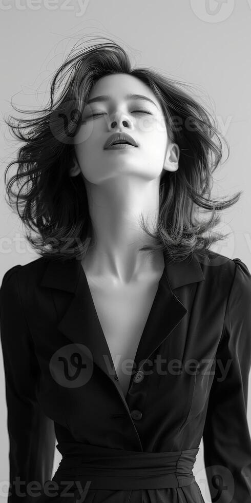 Woman in a black dress with wind-blown hair photo