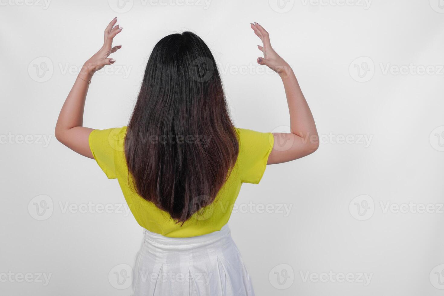 Back portrait of an Asian woman wearing a yellow t-shirt feeling stressed and having headache isolated by white background. photo