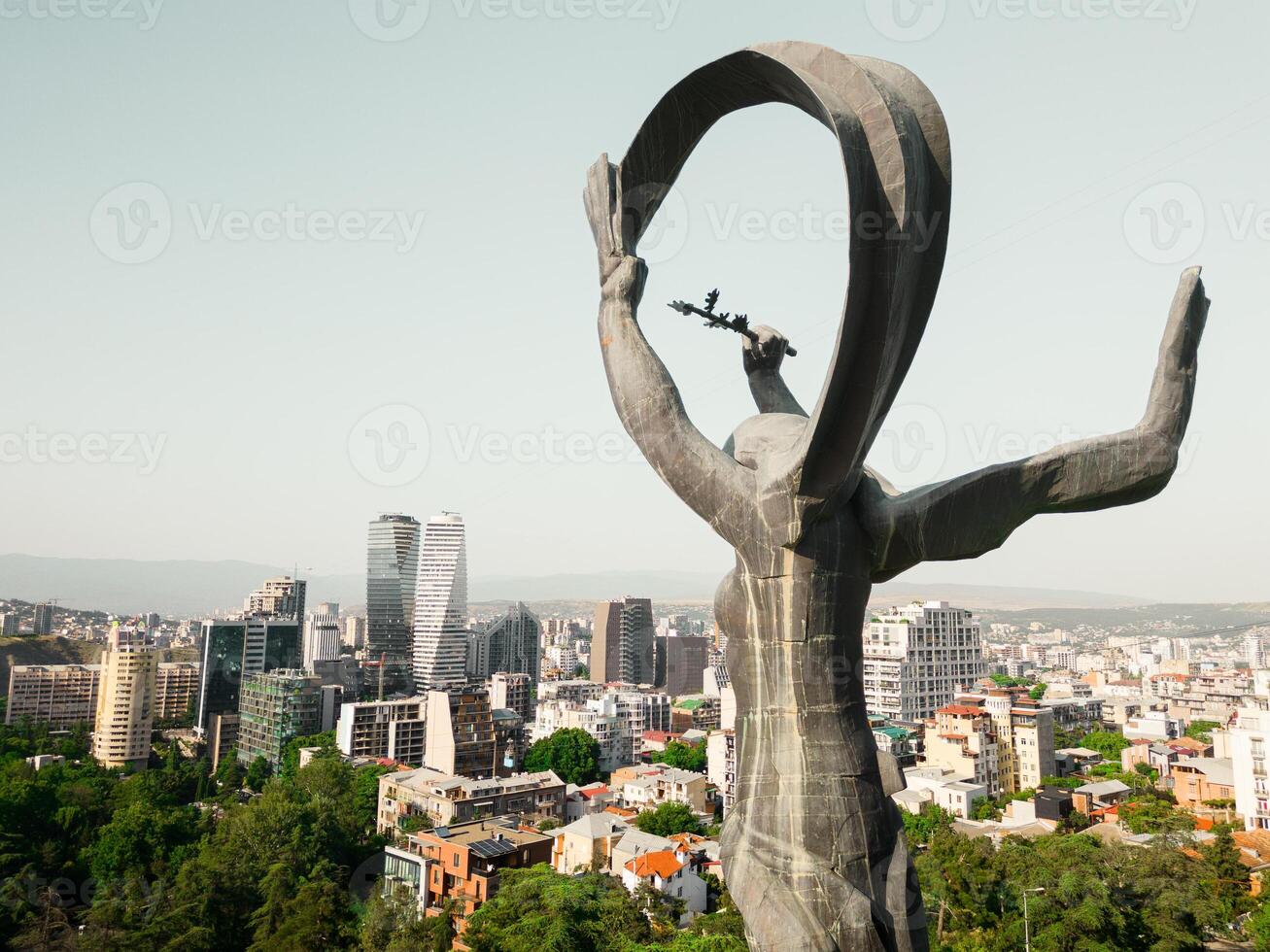 Tbilisi, Georgia -4th july, 2024- Aerial panning view Victory statue, Axis towers and city property and business buildings in vake district. Capital city of Georgia with clear blue sky in sunny day photo