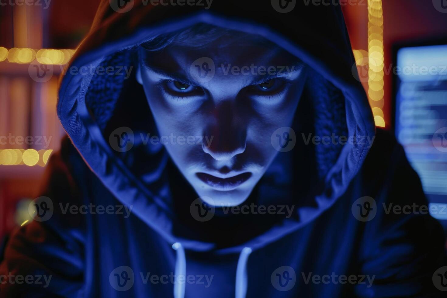Man in a hood, a shadow hides his face on dark background. Anonymous crime concept photo