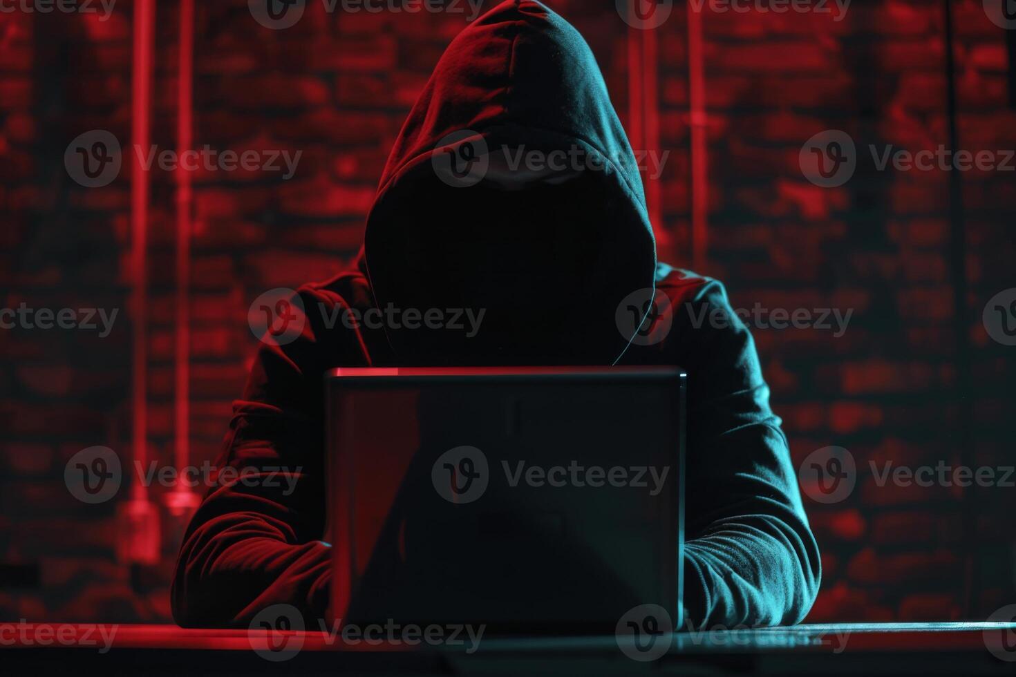 Hacker in hood hacking at computer in dark room. Computer criminal uses malware to hack devices photo